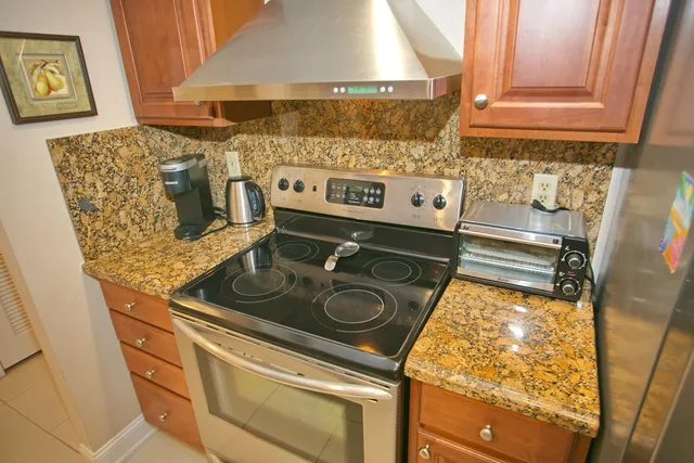 a kitchen with granite countertop a sink a stove and cabinets