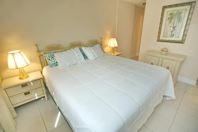 a bedroom with a bed and a flat tv screen on the dresser