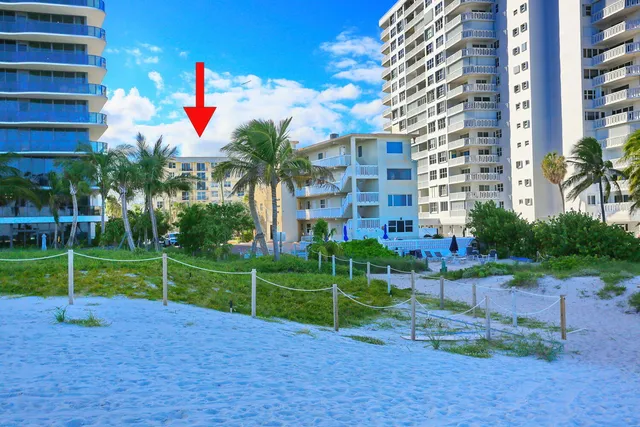 a front view of a building with a garden and plants