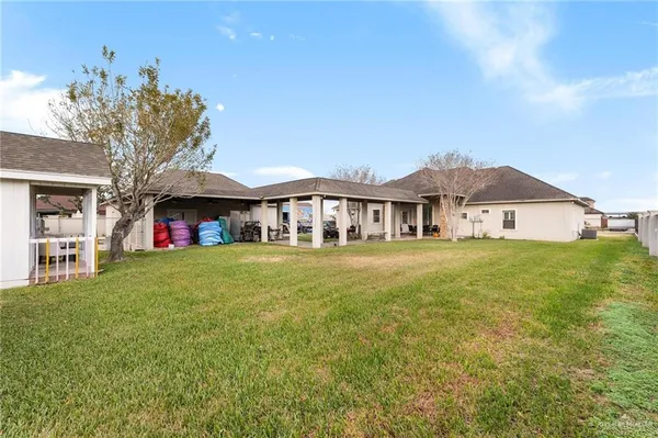 a front view of house with yard and trees in the background