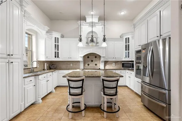 a kitchen with granite countertop a sink stainless steel appliances and cabinets
