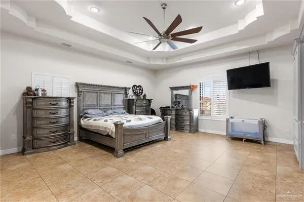 a spacious bedroom with a bed and a flat screen tv