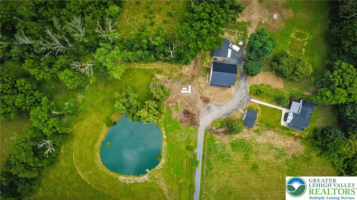 72 Allegheny Road Mount Bethel, PA 18343 - Photo 59 of 72 An aerial panorama reveals a vast green landscape with a serene pond, multiple outbuildings, and a main residence.