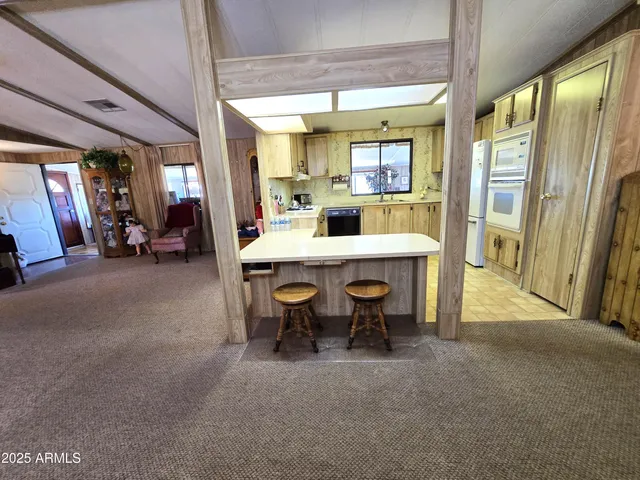 a kitchen with stainless steel appliances kitchen island granite countertop a sink and a cabinets