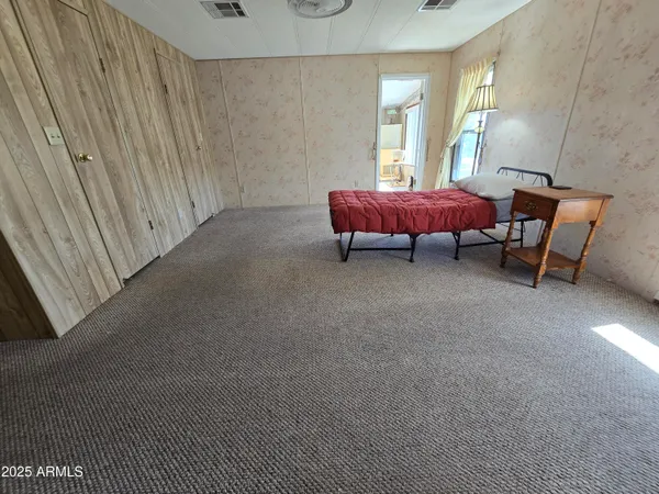 a bed sitting in a bedroom next to a window