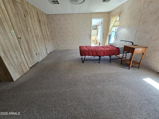 a bed sitting in a bedroom next to a window