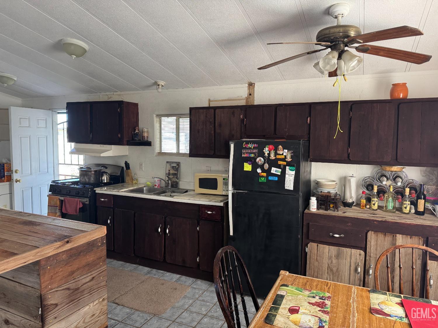 Undisclosed Address Bakersfield, CA 93307 - Photo 5 of 18 a kitchen with granite countertop a refrigerator stove top oven a sink and dishwasher