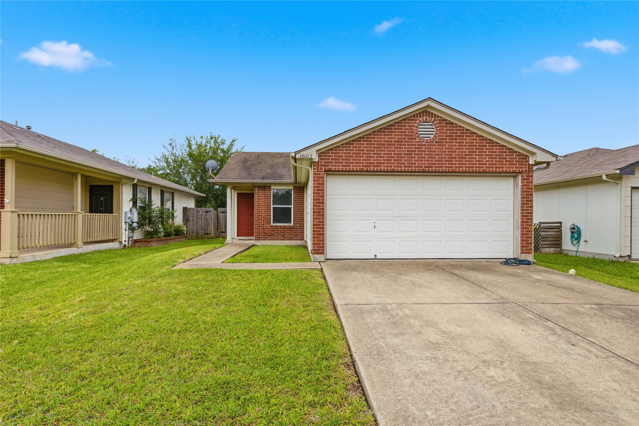 Brick exterior featuring a two-car garage, a concrete driveway, and a front pathway leading to the entry
