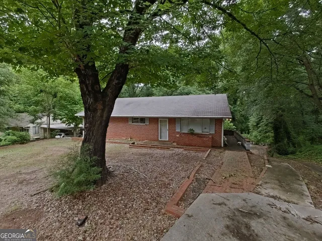 a view of a house with a tree next to a road