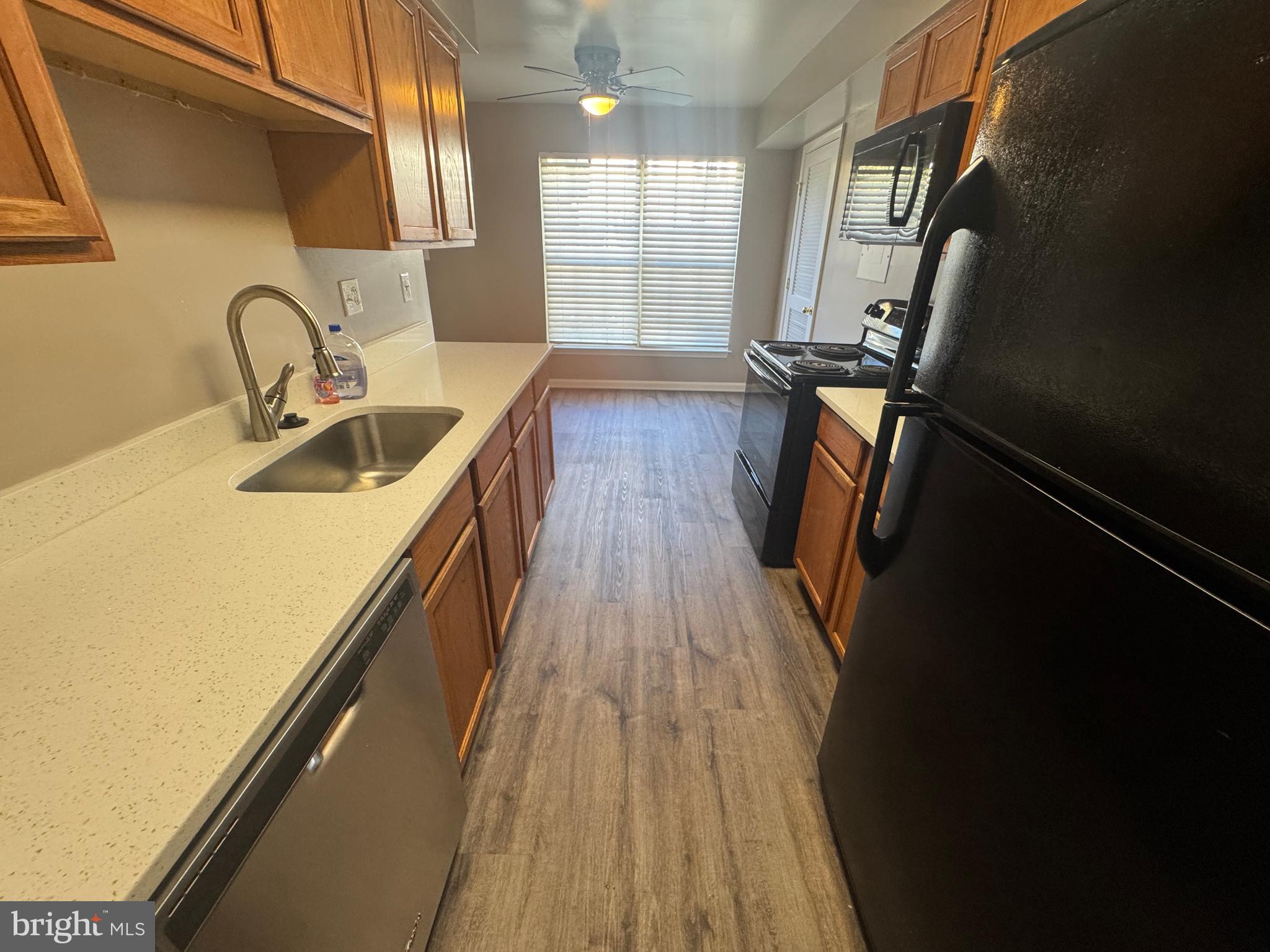 11263 Raging Brook Drive, Unit 253 Bowie, MD 20720 - Photo 10 of 22 a kitchen with sink a refrigerator and wooden floor