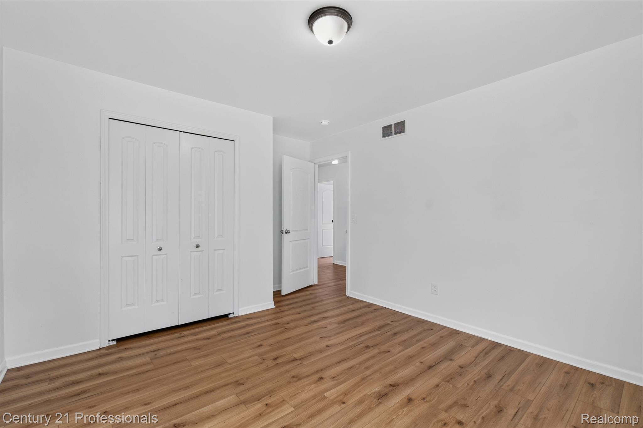 2042 Decker Road Walled Lake, MI 48390 - Photo 31 of 48 Bedroom 3 Spacious room featuring wood-finish flooring, white walls, and a ceiling-mounted light fixture