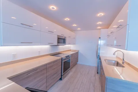 a kitchen with kitchen island a sink and wooden floor