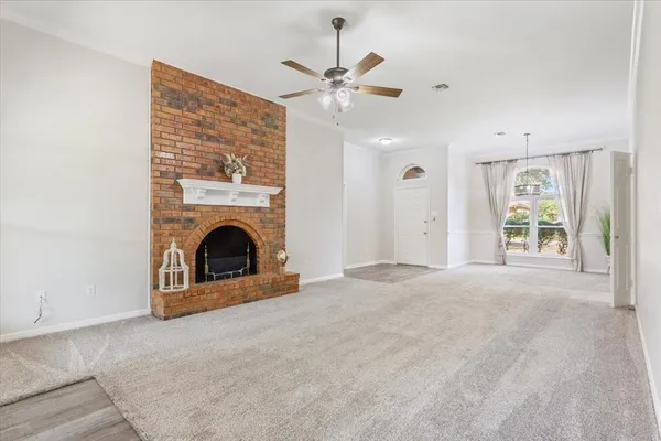 a view of a livingroom with a ceiling fan and fireplace