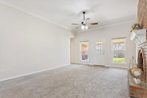 an empty room with windows and fireplace