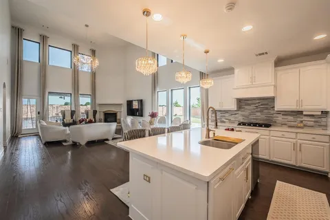 a kitchen with sink stove and living room view
