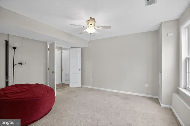 a view of a livingroom with a ceiling fan and a bathroom