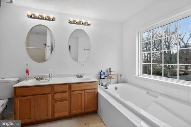 a bathroom with a tub sink and mirror