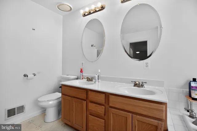 a bathroom with a double vanity sink and a mirror