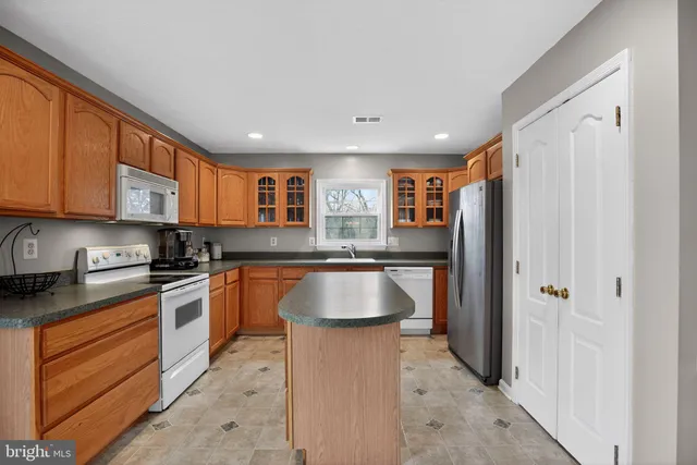 a kitchen with stainless steel appliances granite countertop a refrigerator and a stove top oven