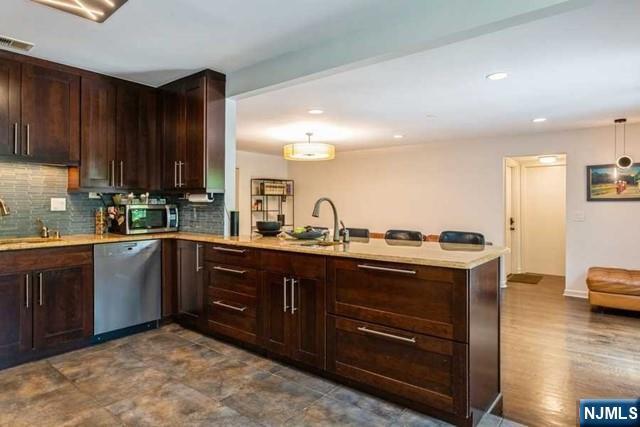 437 Summit Street Englewood Cliffs, NJ 07632 - Photo 8 of 25 a kitchen with stainless steel appliances granite countertop a sink and cabinets