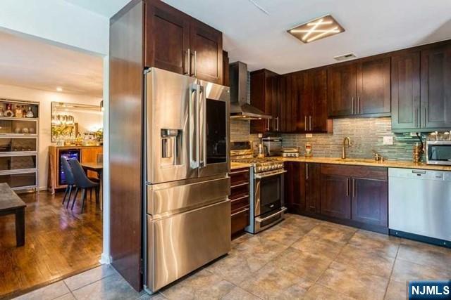 437 Summit Street Englewood Cliffs, NJ 07632 - Photo 10 of 25 a kitchen with stainless steel appliances a refrigerator a stove a sink cabinets and a dining table