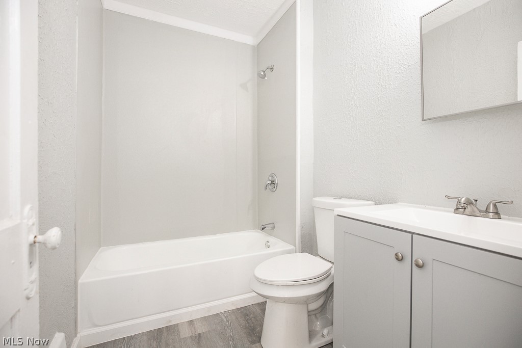 1000 Eddy Road Cleveland, OH 44108 - Photo 13 of 38 Full bath with a textured wall, vanity, wood finished floors, tub / shower combination, and a textured ceiling
