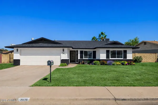 a front view of a house with a garden and yard