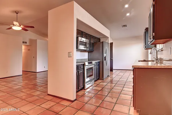 a kitchen with stainless steel appliances a refrigerator and a stove top oven