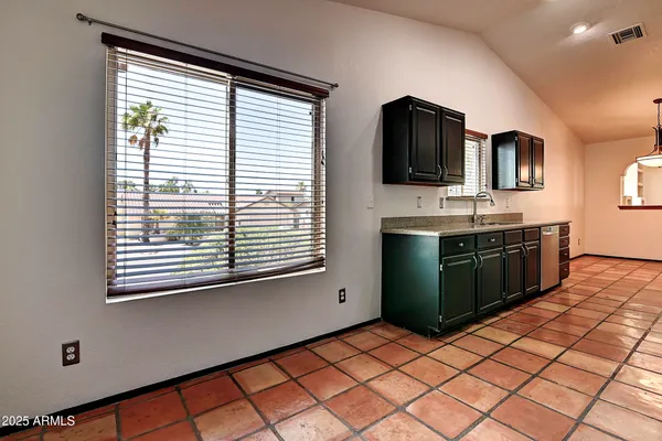 a kitchen with a sink window and cabinets