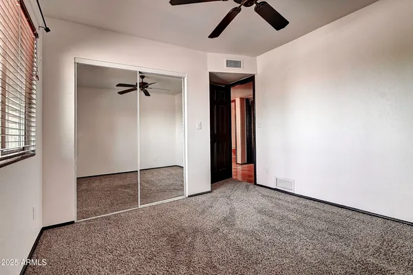 an empty room with closet and windows