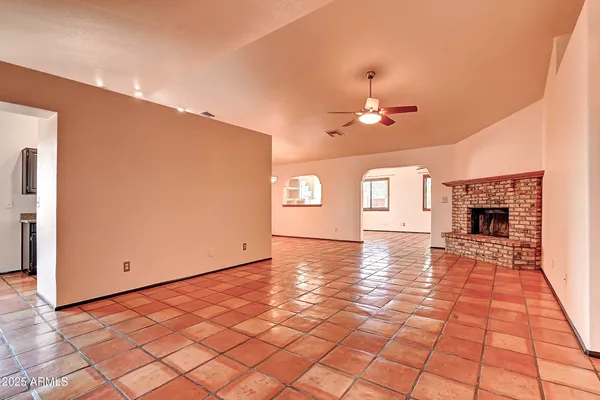 a view of an empty room with window and fireplace