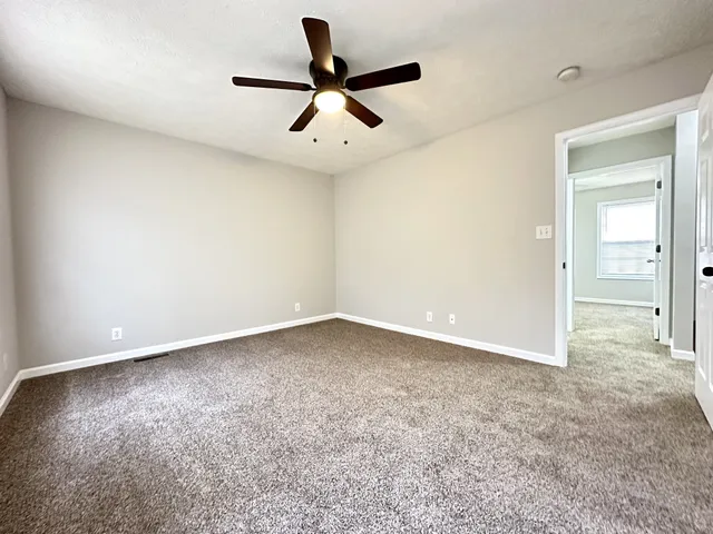 an empty room with closet and windows