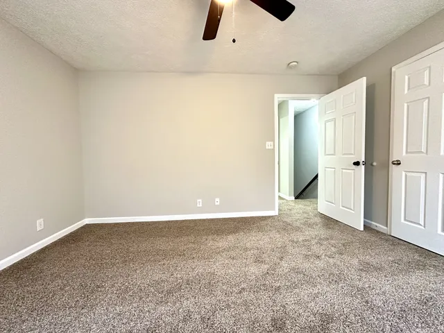 an empty room with closet and windows