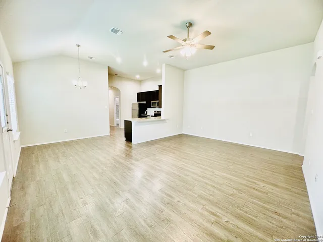 a view of empty room with wooden floor