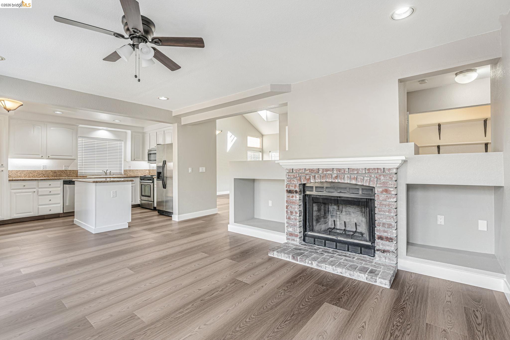 5052 Perry Way Antioch, CA 94531 - Photo 11 of 51 a living room with stainless steel appliances kitchen island a fireplace and a ceiling fan