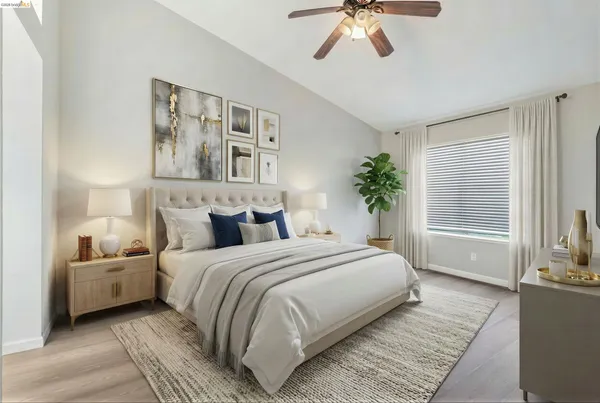 a bedroom with a large bed a chandelier and windows