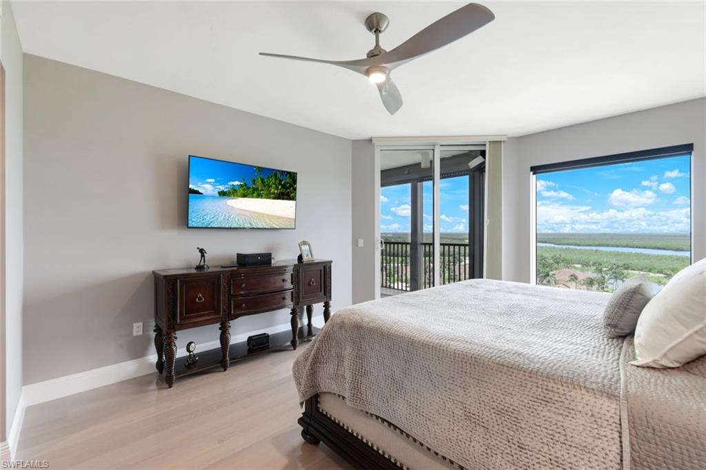 1060 Borghese Lane, Unit 902 Naples, FL 34114 - Photo 14 of 24 a bedroom with a bed a large window and a flat screen tv