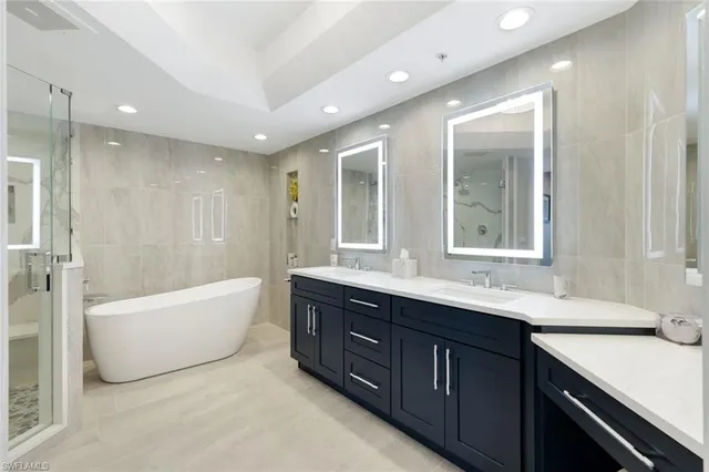 a bathroom with a tub sink shower and mirror