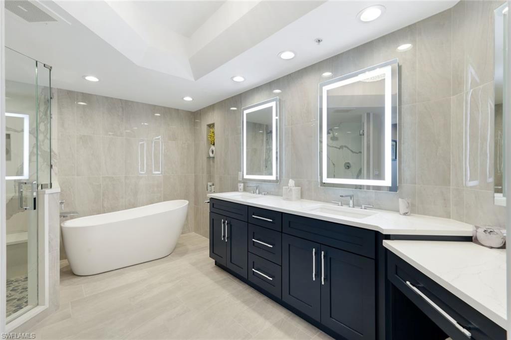 1060 Borghese Lane, Unit 902 Naples, FL 34114 - Photo 15 of 24 a bathroom with a tub sink shower and mirror