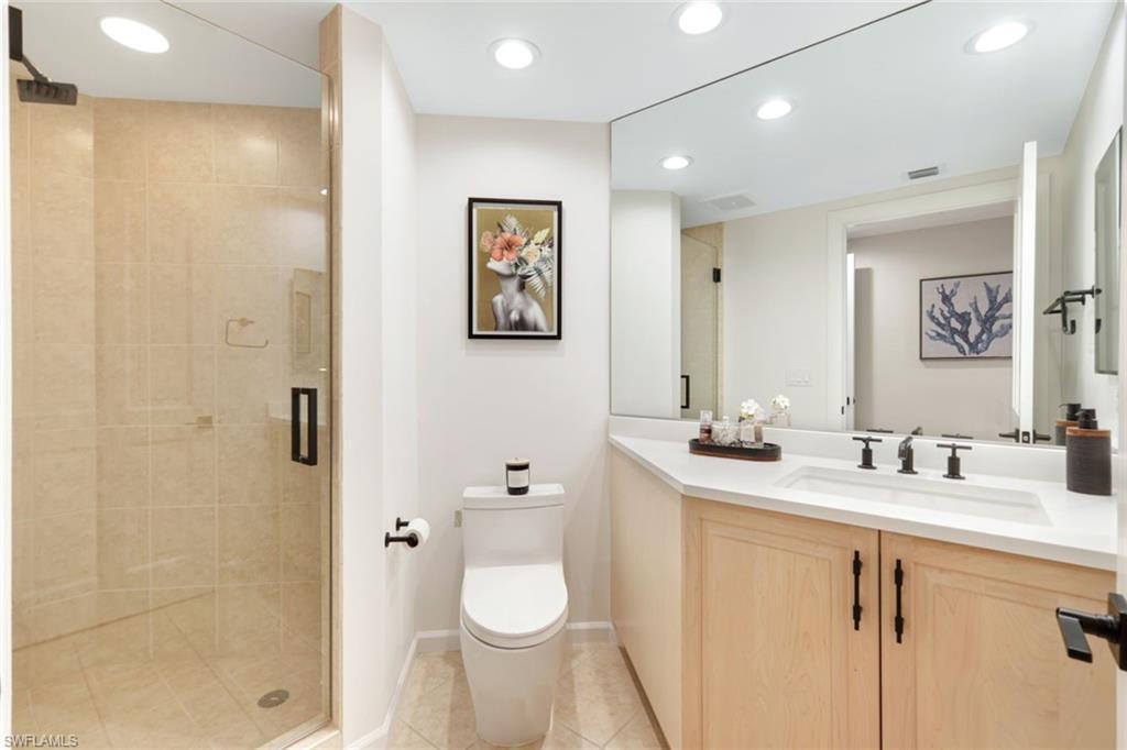 1060 Borghese Lane, Unit 902 Naples, FL 34114 - Photo 17 of 24 a bathroom with a granite countertop sink toilet and shower