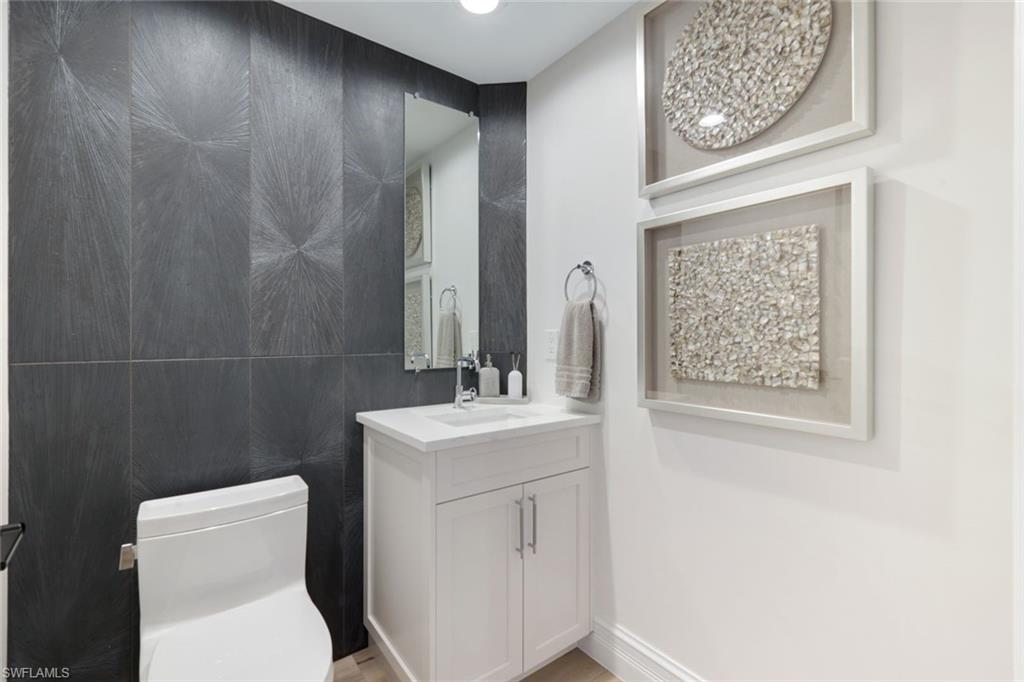 1060 Borghese Lane, Unit 902 Naples, FL 34114 - Photo 19 of 24 a bathroom with a toilet sink and mirror