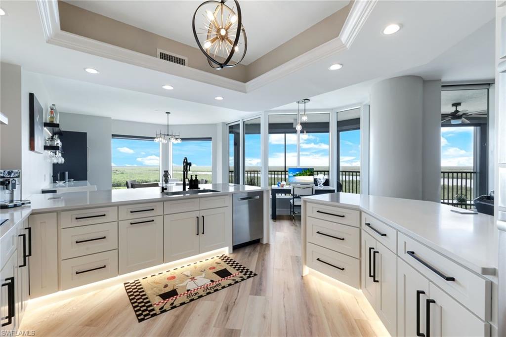1060 Borghese Lane, Unit 902 Naples, FL 34114 - Photo 3 of 24 a kitchen with stainless steel appliances kitchen island granite countertop a sink and cabinets