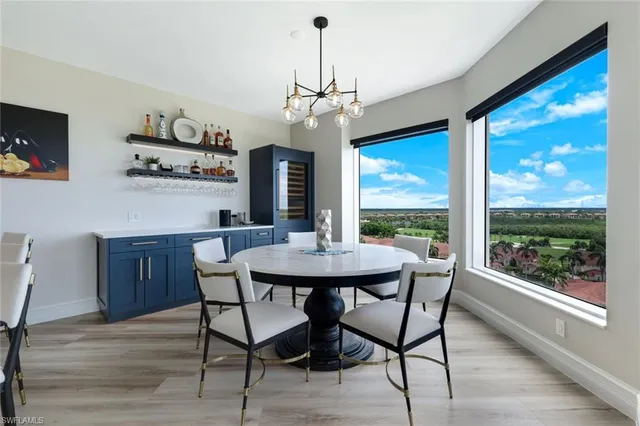 a dining room with furniture a chandelier and wooden floor
