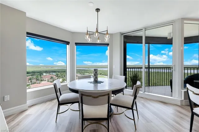 a dining room with furniture a chandelier and wooden floor