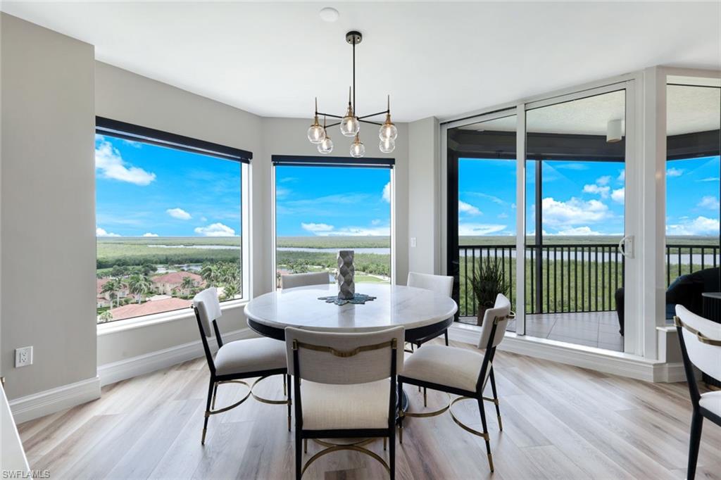 1060 Borghese Lane, Unit 902 Naples, FL 34114 - Photo 8 of 24 a dining room with furniture a chandelier and wooden floor