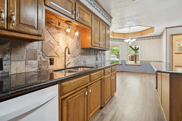 a kitchen with stainless steel appliances granite countertop a sink a stove and cabinets