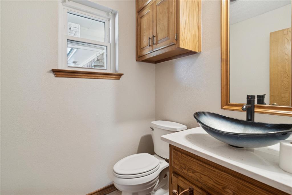 2300 Union Hill Road Sanger, TX 76266 - Photo 16 of 34 a bathroom with a toilet a sink and mirror