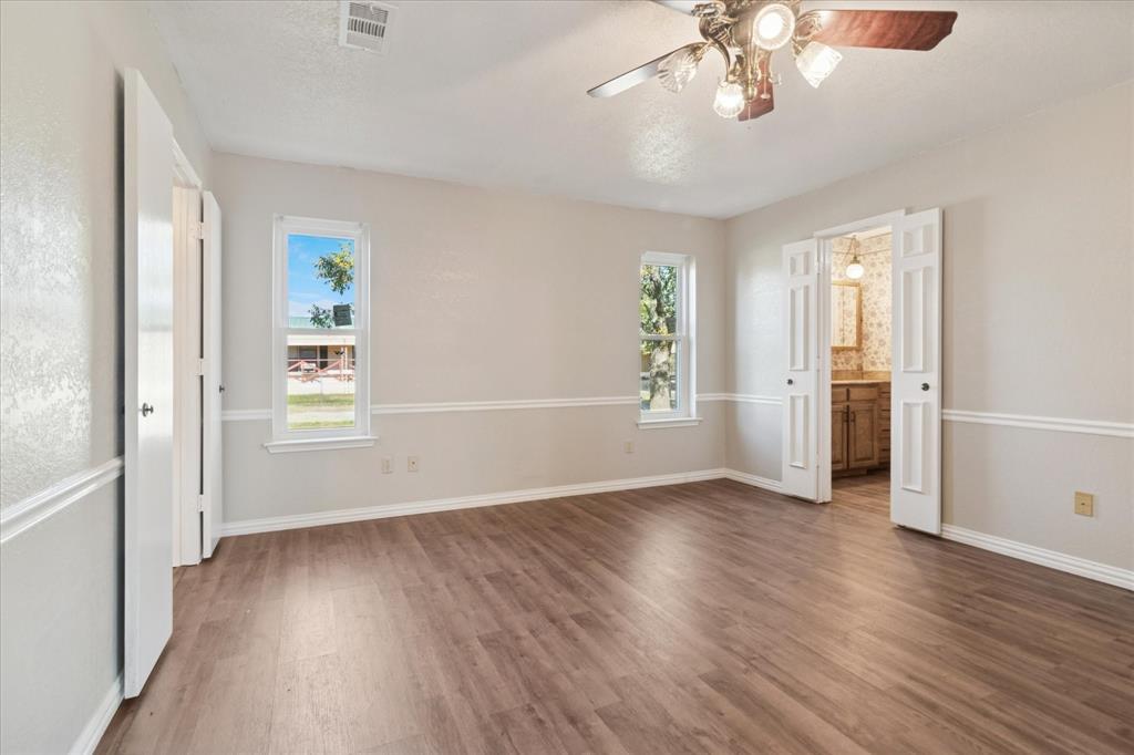 2300 Union Hill Road Sanger, TX 76266 - Photo 22 of 34 an empty room with wooden floor chandelier and windows