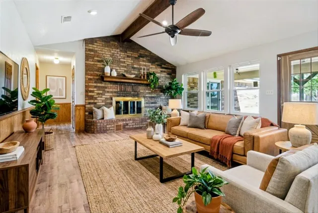 a living room with furniture ceiling fan and a large window