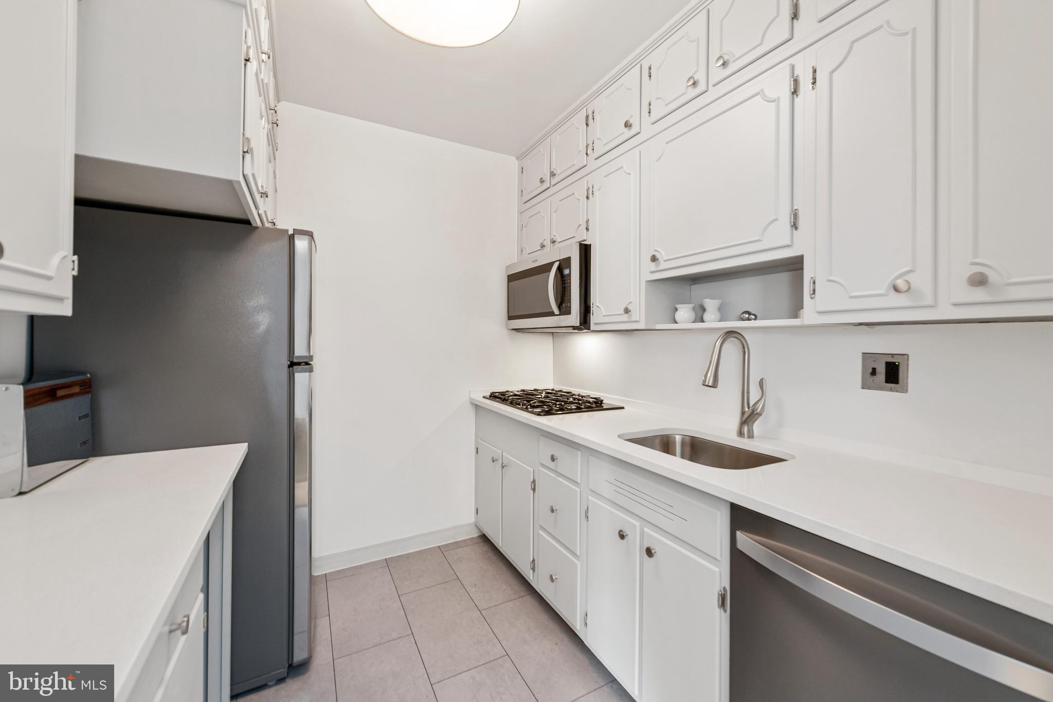2475 Virginia Avenue Northwest, Unit 700 Washington, DC 20037 - Photo 14 of 36 a kitchen with stainless steel appliances granite countertop a sink stove and refrigerator
